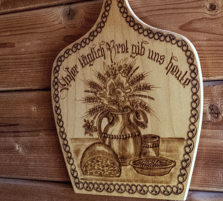 Geschnitzte Holztafel am Hof